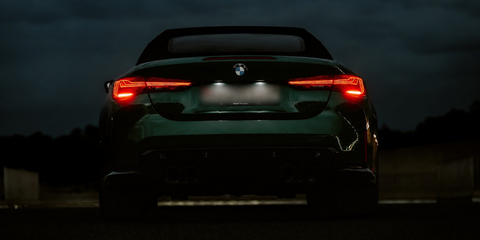Vue arrière nocturne d’une BMW M4 Competition verte
